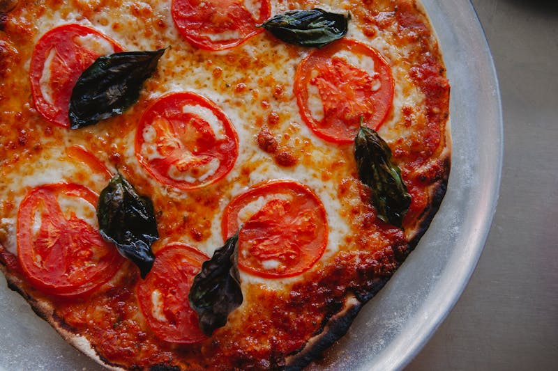 Classic Margherita coal fired pizza with fresh basil and charred crust